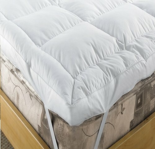 Plush white mattress topper on a bed.