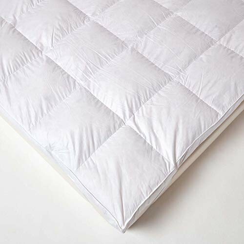 White quilted mattress topper on a bed.