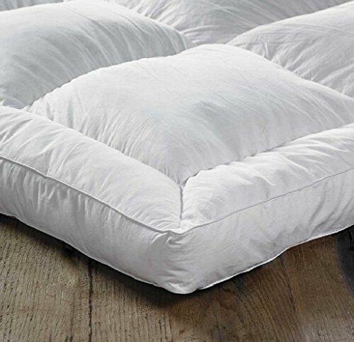 White quilted mattress topper on wooden floor