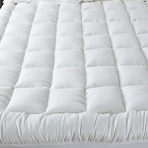 White quilted mattress topper with a soft, padded surface.